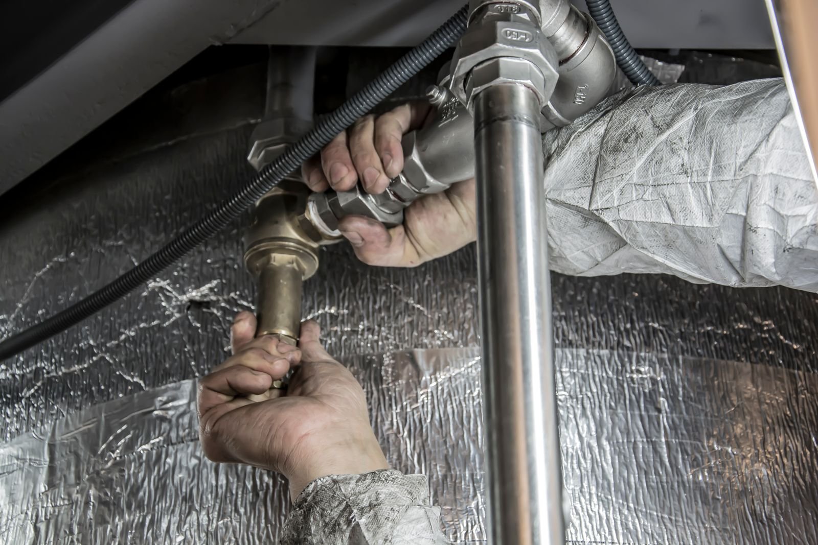 Plumber fitting steel pipes during a repair